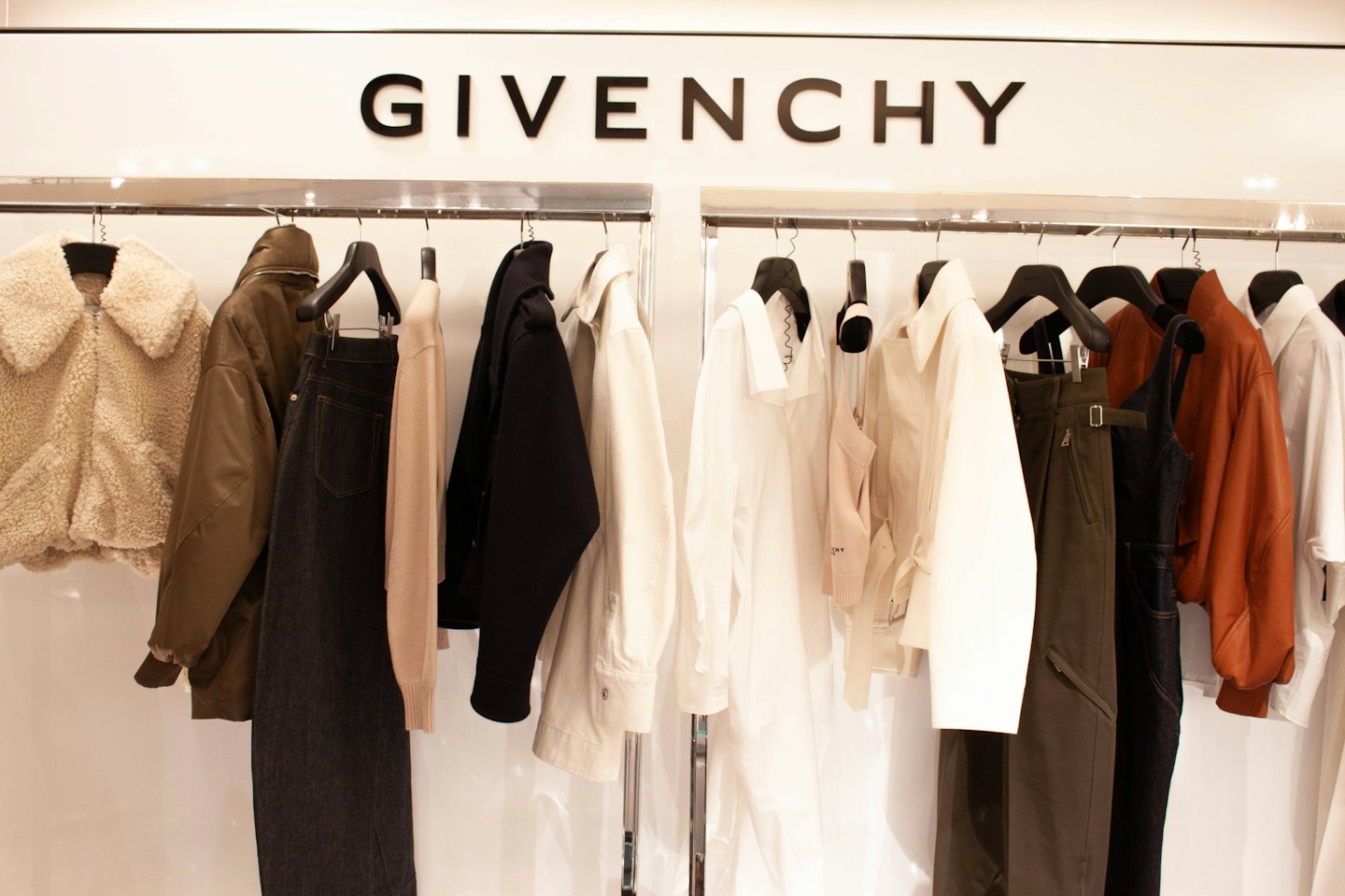 Abbigliamento di lusso appeso ordinatamente su due rastrelliere sotto l'insegna Givenchy.